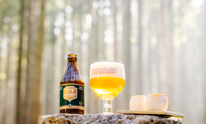 Chimay Groen flesje en glas met kaas in het bos